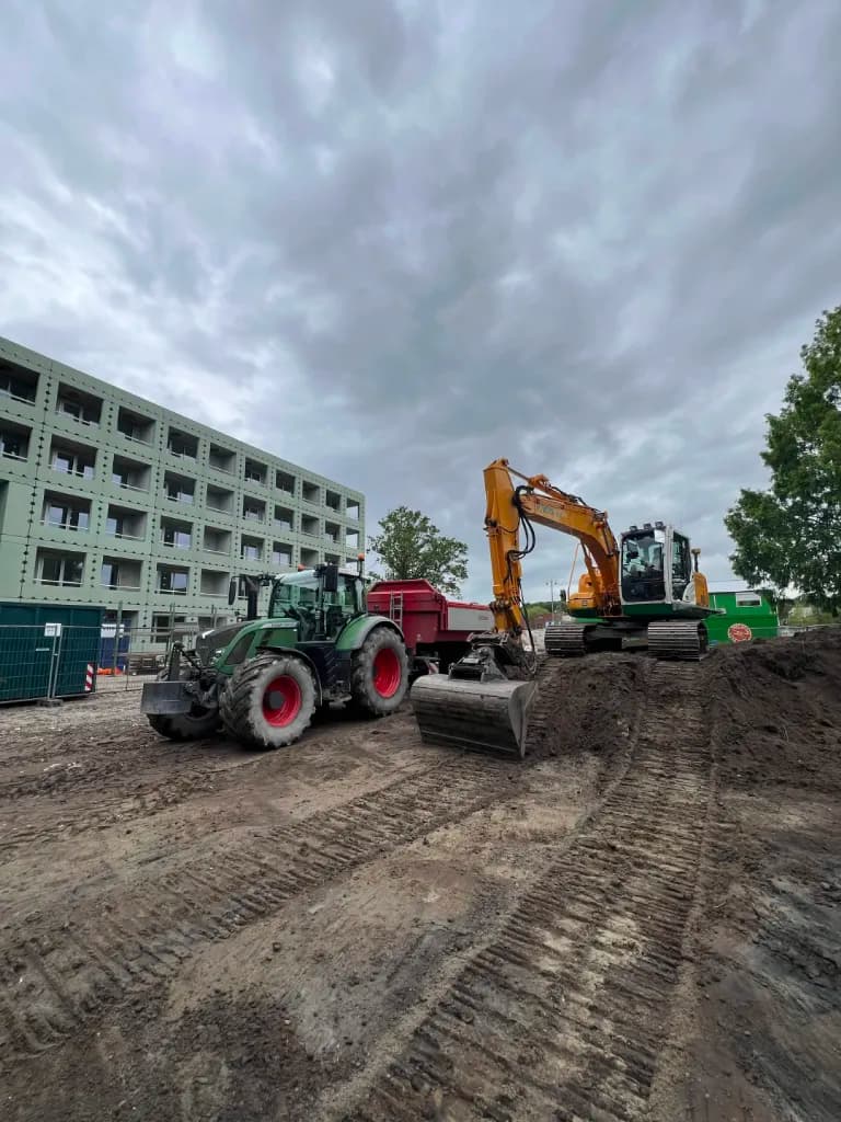 Tractor en graafmachine bij grondwerkzaamheden